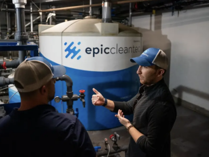 Aaron Tartakovsky, Epic Cleantec CEO, speaks with employee in front of water reuse tank